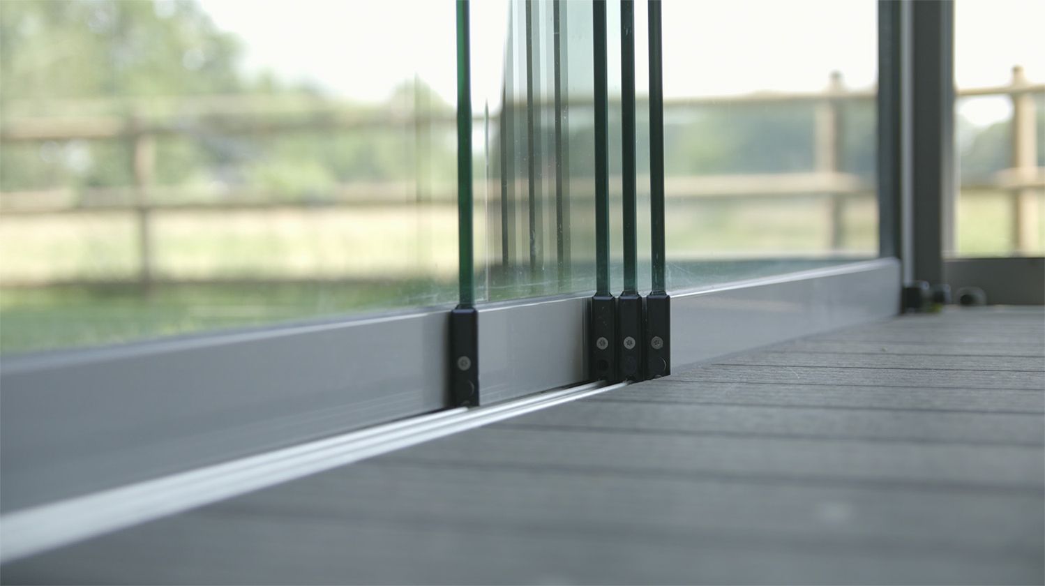 Detailaufnahme einer Glas-Schiebetür mit Holzterrasse